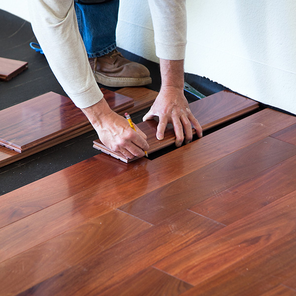 A worker installing hardwood floor in an American upscale home
