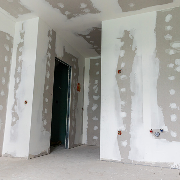 Interior of a house under renovation with drywall installation and joint compound application