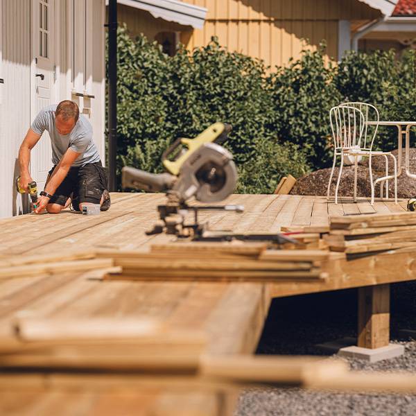 Man building a wooden patio deck outdoors in his garden